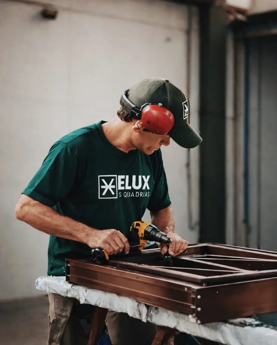 Colaborador da Elux montando uma esquadria de alumínio